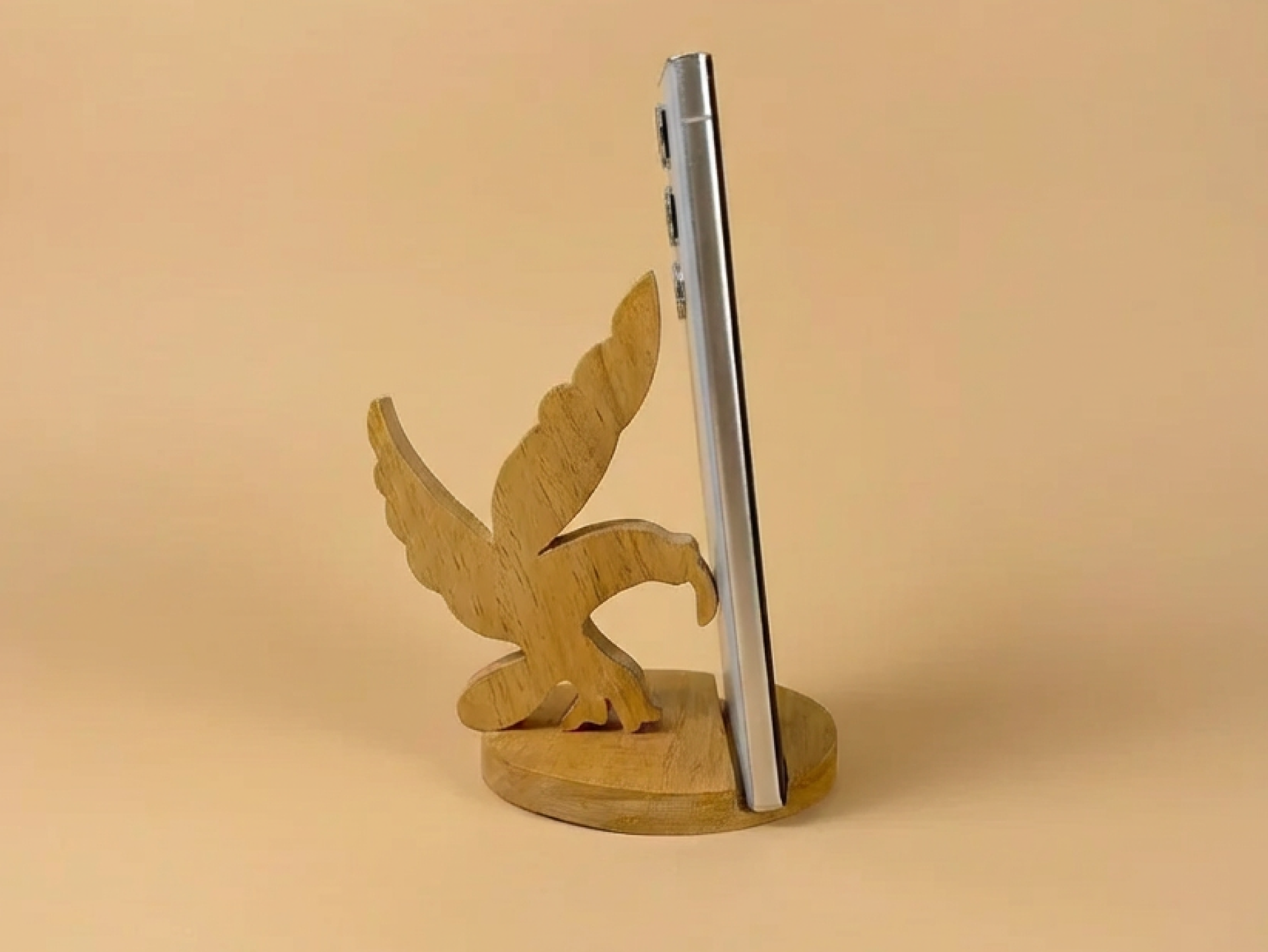 A handcrafted wooden eagle phone stand that offers sturdy phone support with a bold, artistic design.