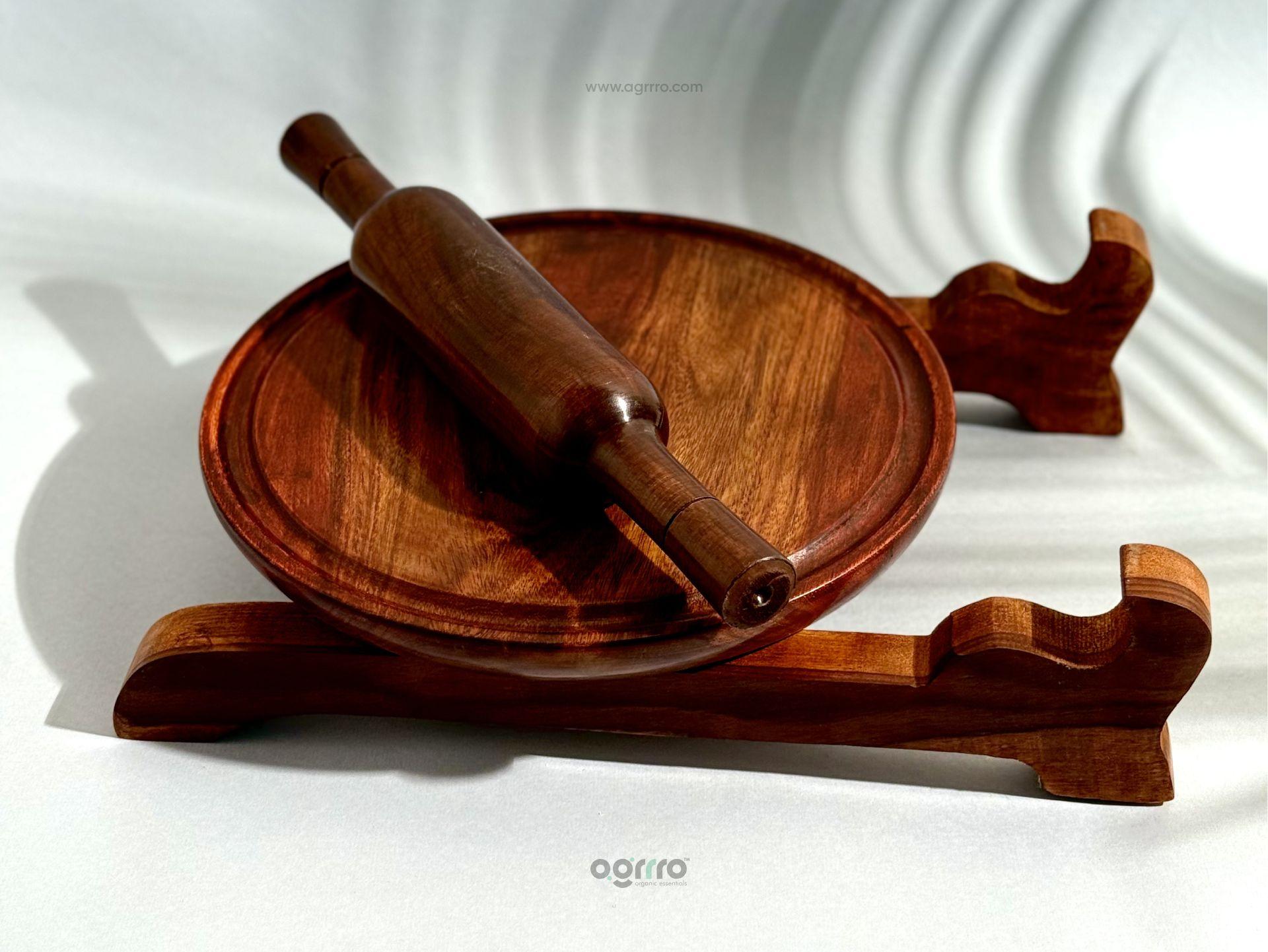 Top view of handcrafted Sheesham wood chakla with belan placed on wooden stand in bright natural light.