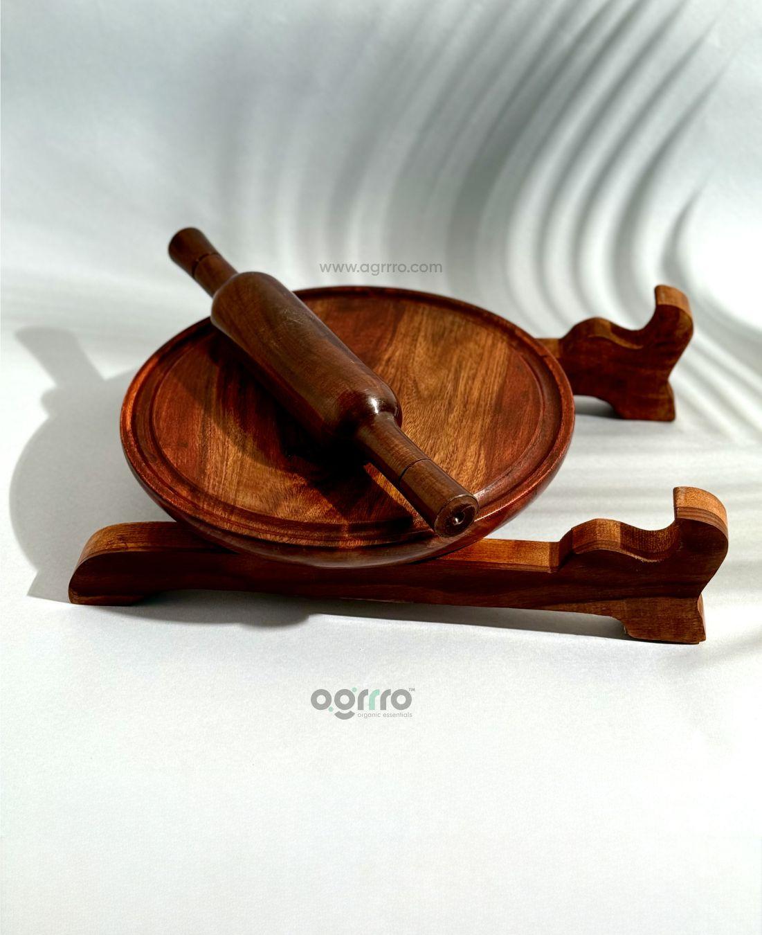 Top view of handcrafted Sheesham wood chakla with belan placed on wooden stand in bright natural light.