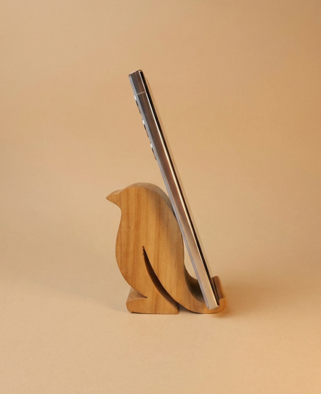 A handcrafted wooden bird-shaped phone stand that blends functionality with minimalist decor.
